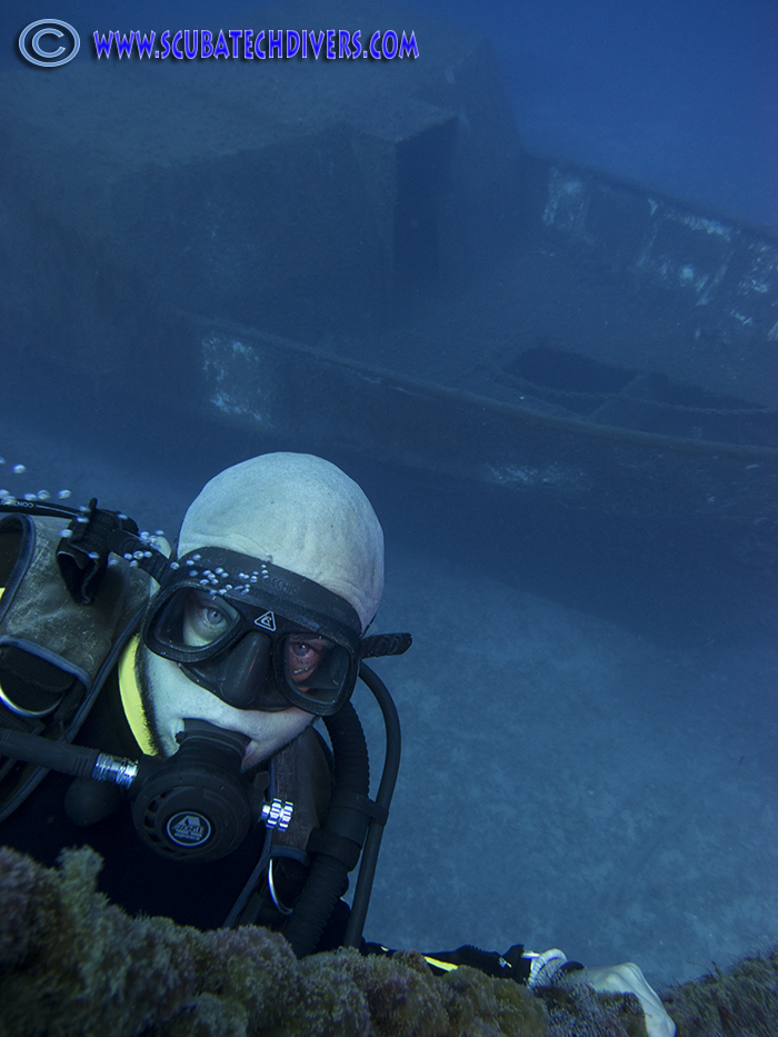 diver scuba diving on shot with liberty wreck in the background