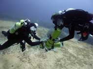technical diving course Divers are deep underwater swapping stage cylinders as technical diving skill