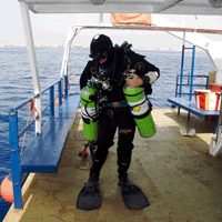 Technical Diver on the Queen Zenobia dive boat in full technical equipment including 2 decompression cylinders