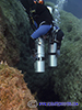 Sidemount diver pulls cylinders in front of him to dive into the blue hole dive site in Protaras